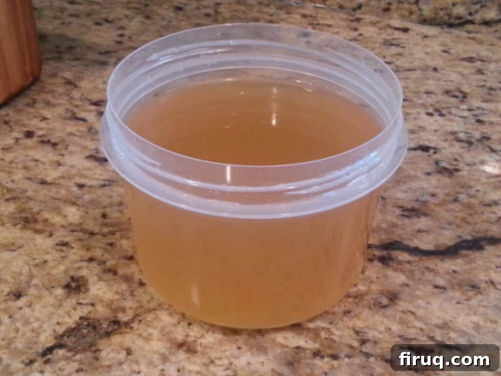 Homemade Chicken Stock 2 A large pot of simmering homemade chicken stock, golden and rich with vegetables and chicken bones.