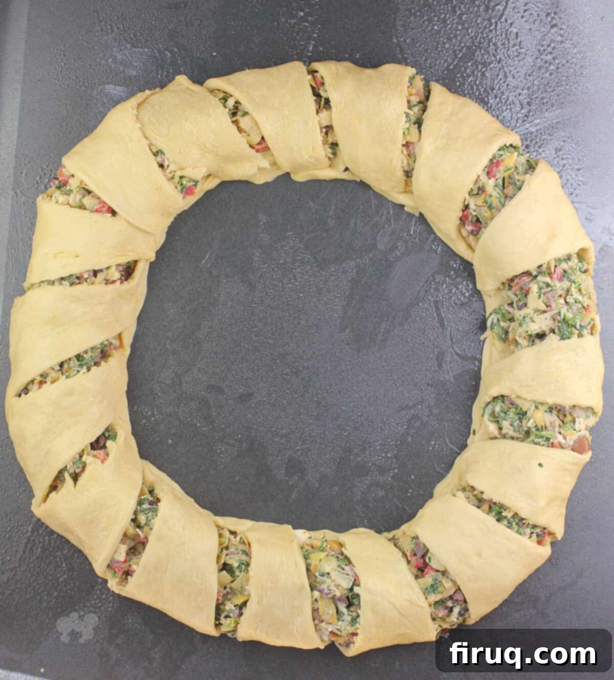 Mediterranean Crescent Wreath 7 Assembled Mediterranean crescent ring, before baking, showing the folded dough over the filling on a baking sheet