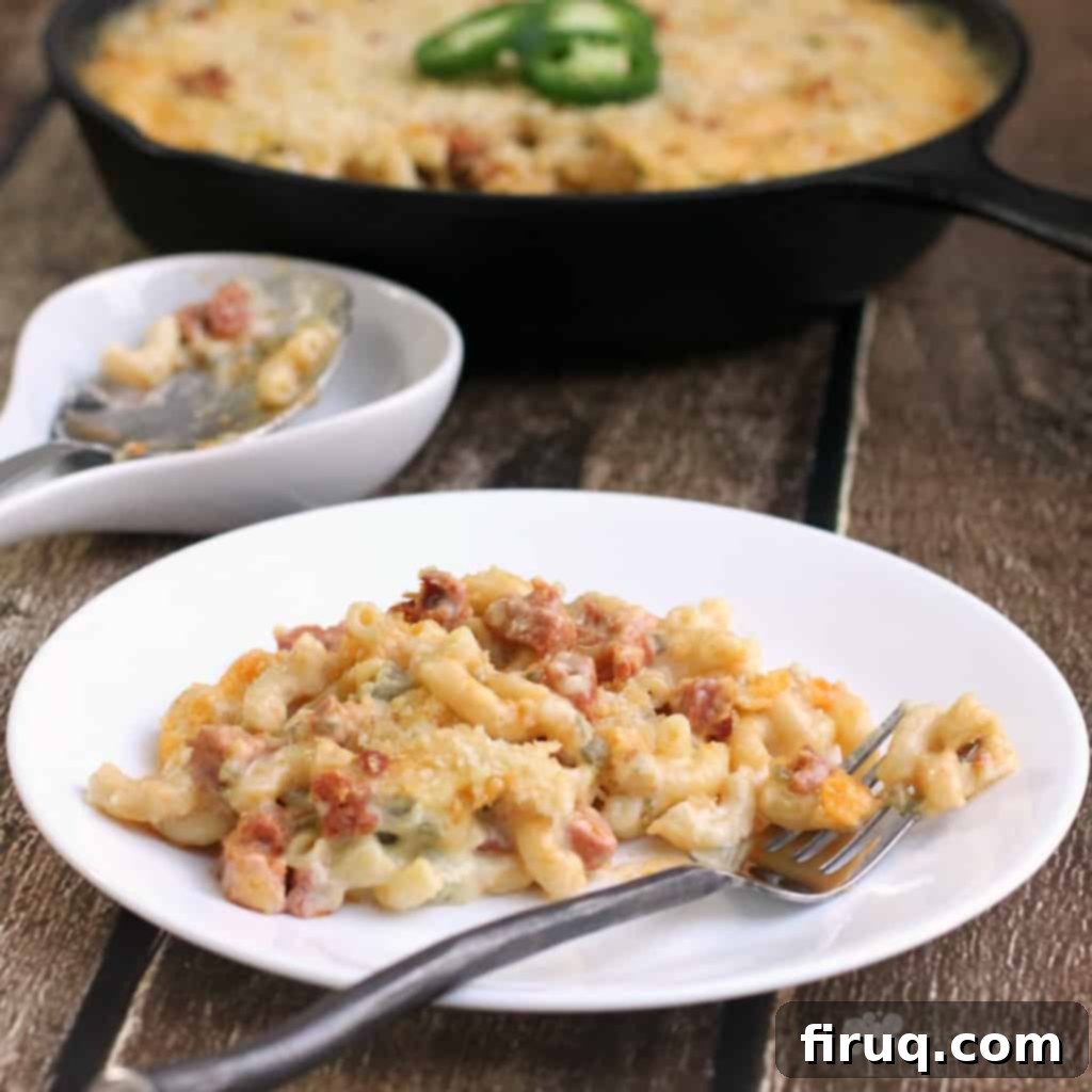 Fiery Chorizo Macaroni Bake 2 Jalapeno and Chorizo Macaroni and Cheese - A close-up shot of the creamy, cheesy pasta with bits of red chorizo and green jalapenos, topped with golden breadcrumbs.