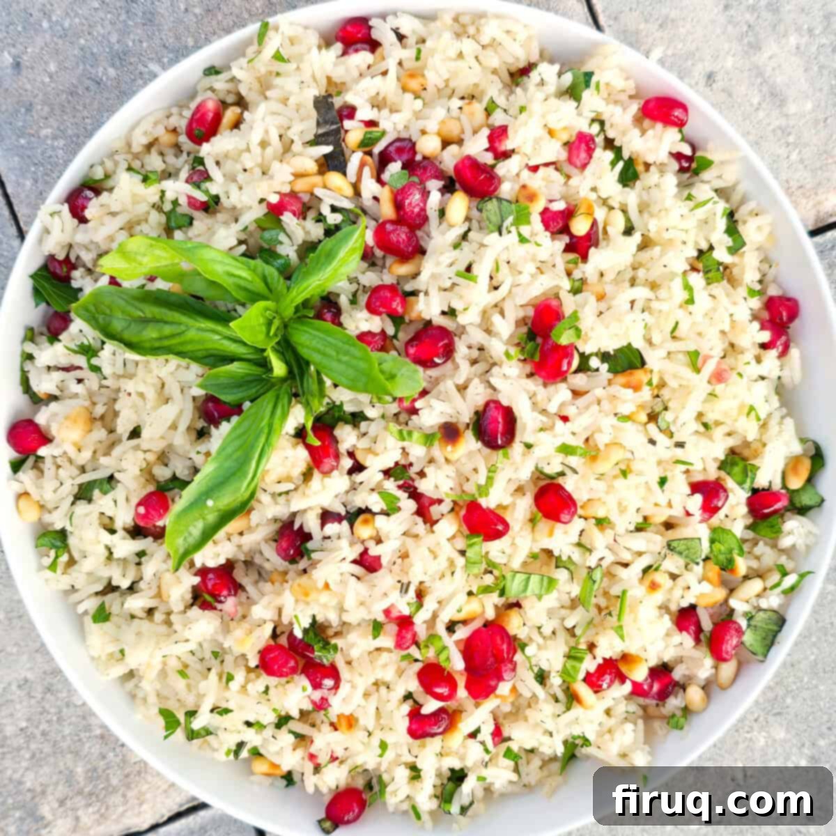 Savory rice salad with pomegranate seeds, fresh herbs, and pine nuts. Perfect for summer parties and healthy side dishes.
